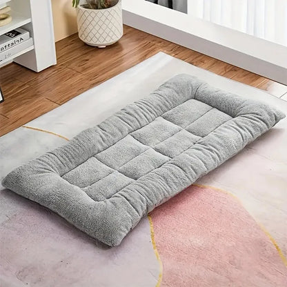 Thick grey plush dog sleeping pad on a rug, top view