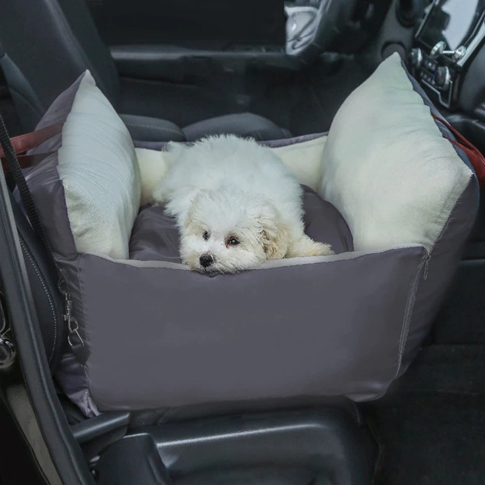 White dog lying in the grey and cream travel car seat bed on a car back seat