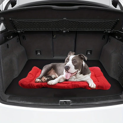 Dog lying on the red roll-up travel mat in a car boot